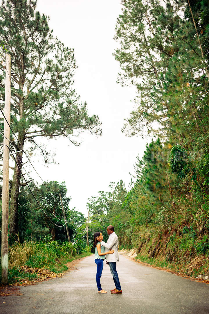 Tall fir trees surround couple standing in the road touching faces in Irish Town Blue Mountain Craighton Jamaica